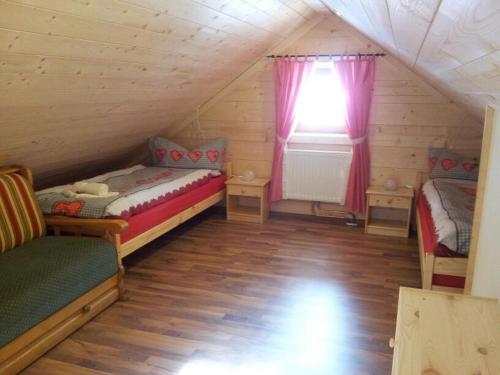 a attic room with two beds and a window at Zimmer im Lungau in Sankt Michael im Lungau