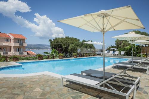 a swimming pool with two chairs and an umbrella at Panorama Fanari studios and apartments in Argostoli