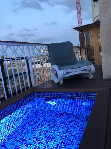 Bett auf einem Balkon mit Pool in der Unterkunft Sweet li in Aschkelon