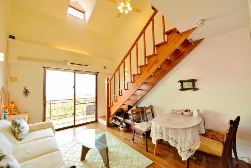 a living room with a table and a staircase at Oceanview Yui in Ishigaki Island