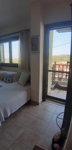 a bedroom with a bed and a view of a balcony at Hill Blue in Nikiti