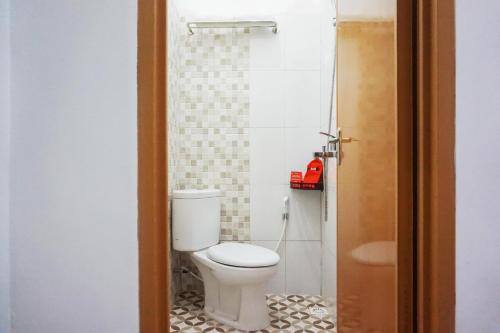 a bathroom with a toilet and a red telephone at RedDoorz @ Jalan Danau Limboto in Malang