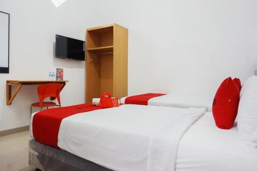 瑪琅的住宿－RedDoorz @ Jalan Danau Limboto，一间卧室配有一张带红色枕头的大床