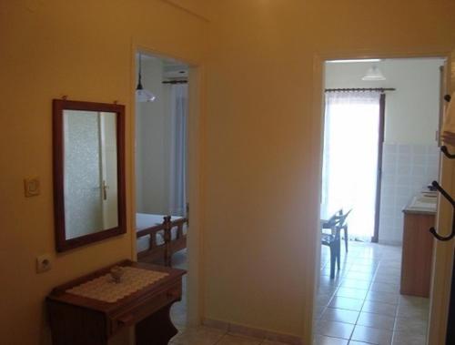 Habitación con espejo y pasillo con lavabo. en Yianna Studios & Apartments, en Gerakini