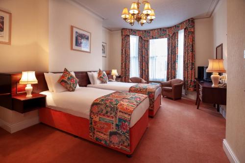 a hotel room with two beds and a television at Arundel House Hotel in Cambridge