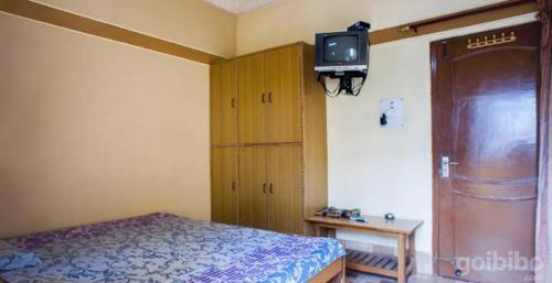 a bedroom with a bed and a tv on the wall at Shri Gobind Highway Motel in Lansdowne
