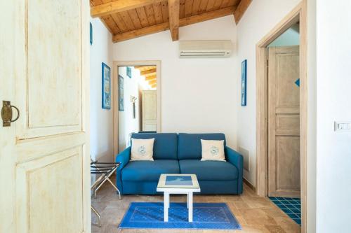 a blue couch in a living room with a table at Villa Flumini in Flumini di Quartu