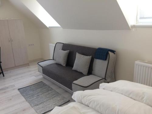 a living room with a couch and a bed at Harmónia Panzió in Bogács