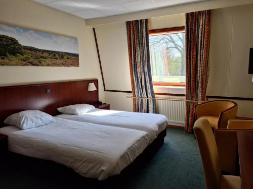 a hotel room with two beds and a window at Fletcher Hotel Restaurant Veldenbos in Nunspeet