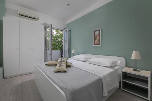 a bedroom with a large bed with a blue wall at Apartmani Dijana in Podgora
