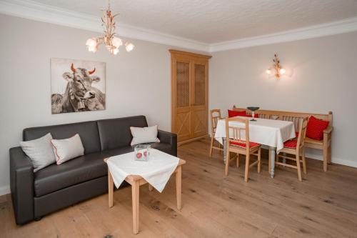 a living room with a black couch and a table at Appartement Erwin & Eleonore Hüttl - Top 1 in Neukirchen am Großvenediger