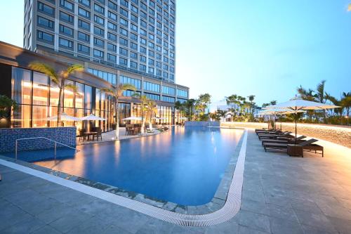 a large swimming pool in front of a building at Hotel Nikko Hai Phong in Hai Phong