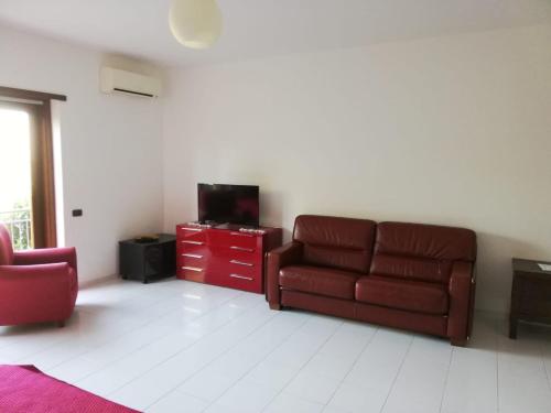 a living room with a couch and a tv at Appartamento Perito in Perito