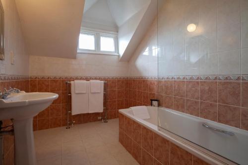 a bathroom with a bath tub and a sink at Ashley Hotel in Cambridge