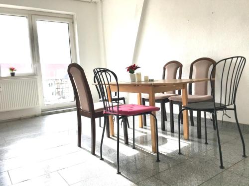 - une table à manger avec des chaises, une table, une table et des chaises dans l'établissement #WORLD Monteurzimmer, à Schkeuditz