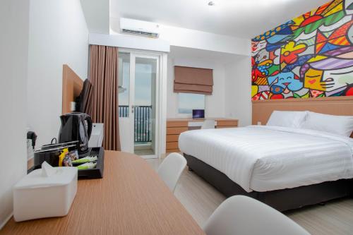 a hotel room with a bed and a desk with a table at Urban Express HomTel - Serpong in Banten