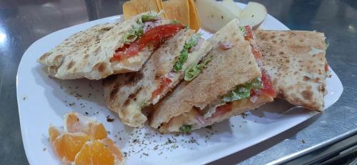 a sandwich is cut in half on a white plate at Apartments Windrose in Kotor