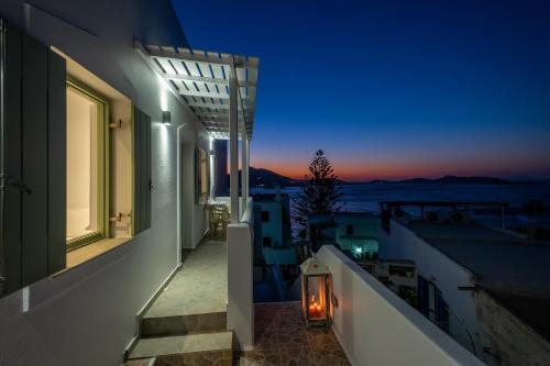 a balcony with a view of the ocean at night at Lorenzo Studios and Suites Paros in Naousa