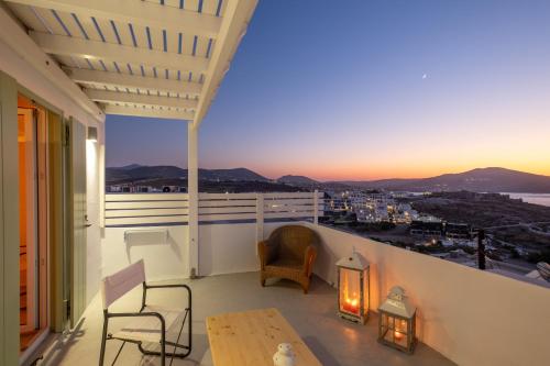 a person sitting on a balcony looking out at the ocean at Lorenzo Studios and Suites Paros in Naousa