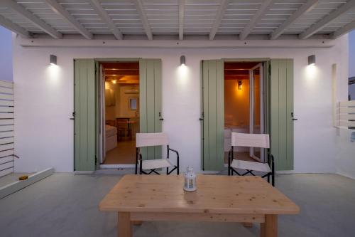 un tavolo e sedie in legno in una stanza con tavolo e sedie. di Lorenzo Studios and Suites Paros a Naoussa