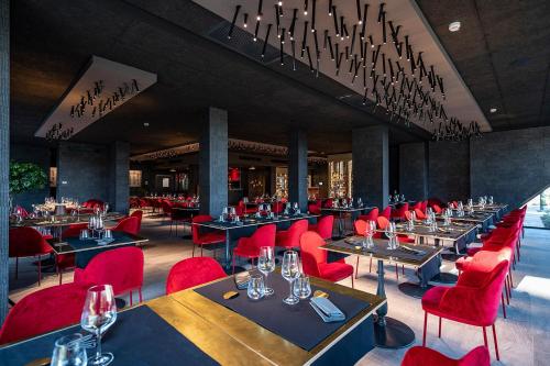 a restaurant with red chairs and tables with wine glasses at Phi Hotel Piajo in Nembro