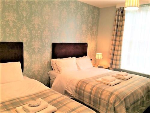 a bedroom with two beds with towels on them at Luther King House in Manchester