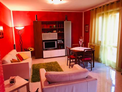 a living room with red walls and a table at CASA MAJA casa per vacanze abruzzo in Lettomanoppello