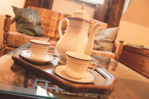 a tea pot and two cups on a glass table at Siedlisko Sabinowo in Węgorzewo