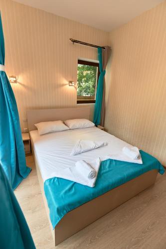 a bedroom with a bed with two towels on it at Stanford Aparthotel Gara de Nord in Bucharest