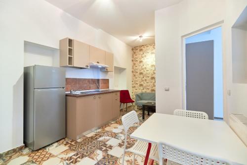 a kitchen with a refrigerator and a table and chairs at Stanford Aparthotel Gara de Nord in Bucharest