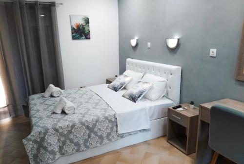 Un pequeño dormitorio con una cama blanca y una mesa en Penny's Holiday Studio, en Chaniotis