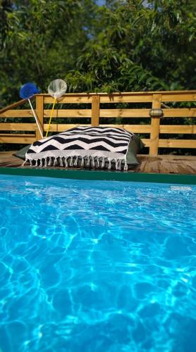 a bed sitting next to a blue swimming pool at Kedra Village in Kédra