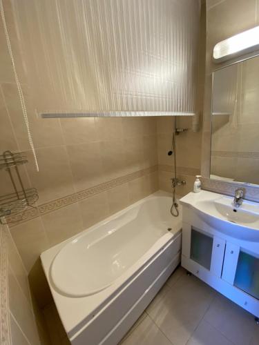 a white bathroom with a tub and a sink at Apartament Viva Predeal in Predeal