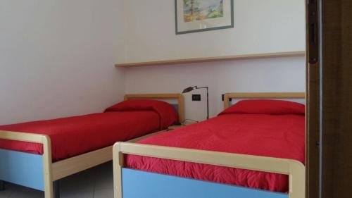 una camera da letto con due letti con lenzuola rosse di Welcome Traveller CASA MARA a Lazise