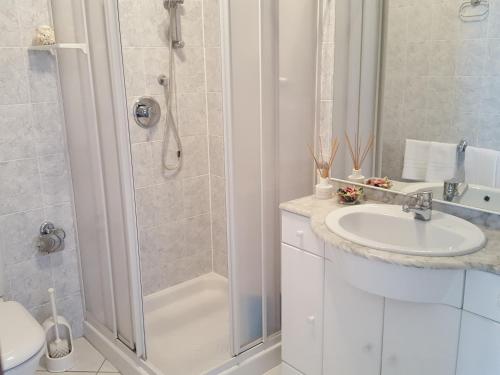 un bagno con doccia, lavandino e WC di Welcome Traveller CASA MARA a Lazise