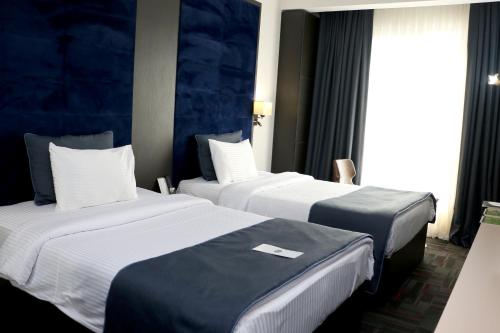 Cette chambre comprend 2 lits et une fenêtre. dans l'établissement My House Hotel, à Samsun