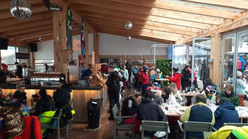 a group of people sitting at tables in a restaurant at Club Rossignol in Poiana Brasov