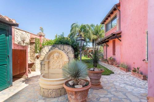 a garden with potted plants in front of a building at Villa Flumini in Flumini di Quartu