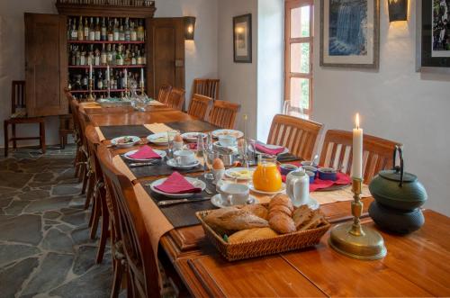 蒂纳霍Villa El Inti的一张长长的木桌上放着面包和蜡烛。