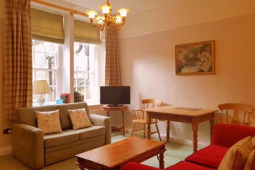 a living room with a couch and a table at No 6 The Square Tearooms & Accommodation in Buxton