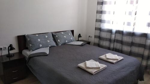 a bedroom with a bed with towels on it at Fly Up Home apartment in Boryspilʼ