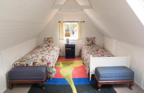 a attic room with two beds and a window at Anne Just's Havehotel in Blokhus