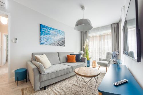 een woonkamer met een bank en een tafel bij Apartamenty Sun & Snow Residence II Jastrzębia Góra in Jastrzębia Góra