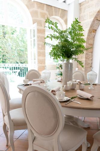 a white dining room with a table and chairs at Pavillon des Millésimes, Piscine & SPA in Lussac