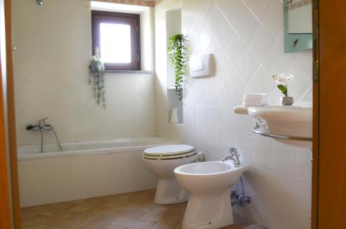 a white bathroom with a toilet and a sink at Caratteristico appartamento nel cuore della Tuscia in Vetralla