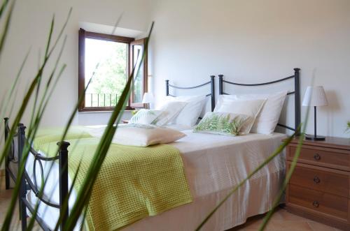 a bedroom with a bed with white sheets and a window at Caratteristico appartamento nel cuore della Tuscia in Vetralla
