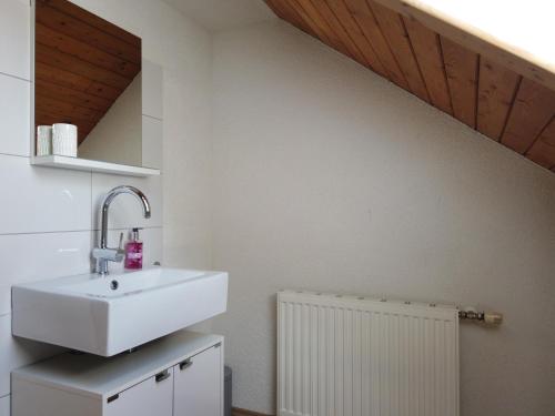 La salle de bains est pourvue d'un lavabo blanc et d'un radiateur blanc. dans l'établissement Ferienhaus Oma Hase, à Mürzzuschlag