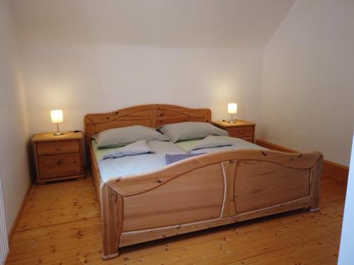 ein Schlafzimmer mit einem Holzbett mit zwei Nachttischen in der Unterkunft Ferienhaus Oma Hase in Mürzzuschlag