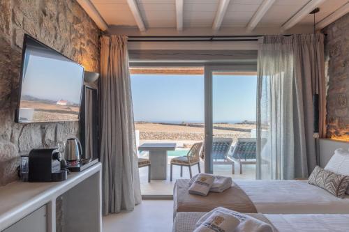 a hotel room with a bed and a view of the ocean at Aegean Hospitality in Mýkonos City