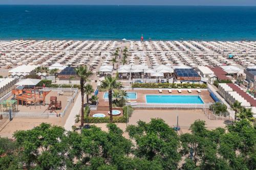 een luchtzicht op een resort met een zwembad en een strand bij Hotel Lungomare in Riccione